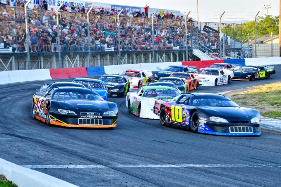 Cars known as super late models pace in front of the North End grandstands. Super late models have more than 550 horsepower and rank “among the fastest race cars to ever hit the short track,” says iRacing.com.