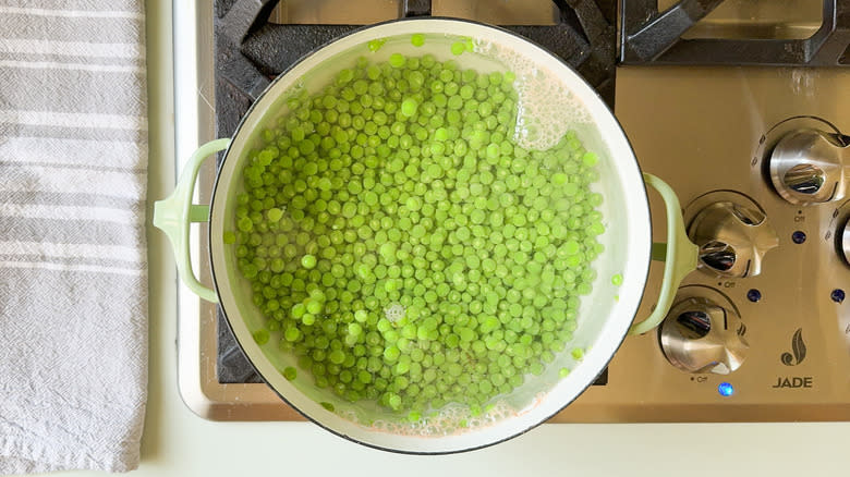 Cooking fresh peas in pot of water