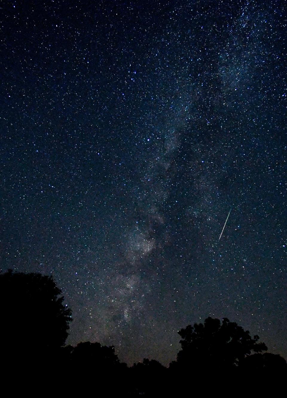 In this file photo from Aug. 12, a meteor is caught as a blurred line in an eight-second exposure of the Milky Way over Abilene State Park, Texas.