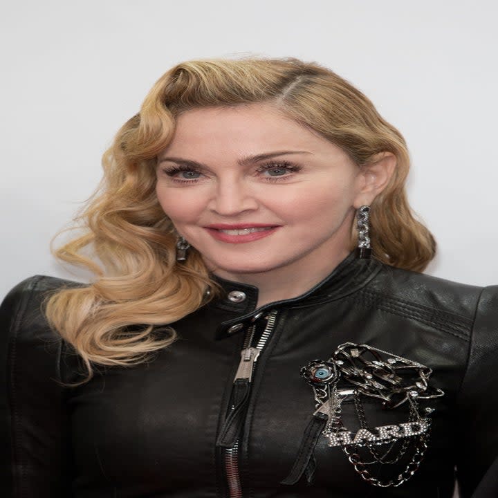 Madonna wearing a leather jacket with a pin that says Hard