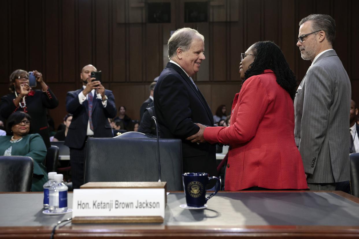 U.S. Supreme Court nominee Judge Ketanji Brown Jackson talks to White House liaison former Senator Doug Jones (L) as her husband Patrick Jackson watches as she arrives for her confirmation hearing before the Senate Judiciary Committee in the Hart Senate Office Building on Capitol Hill on March 22, 2022, in Washington, DC.