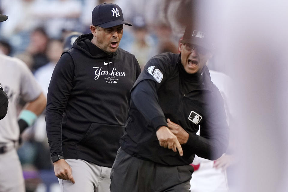 New York Yankees manager Aaron Boone, left, is ejected by second base umpire Vic Carapazza during the first inning of the team's baseball game against the Los Angeles Angels on Wednesday, May 29, 2024, in Anaheim, Calif. Boone argued after Juan Soto was called out at second for runner's interference. (AP Photo/Mark J. Terrill)