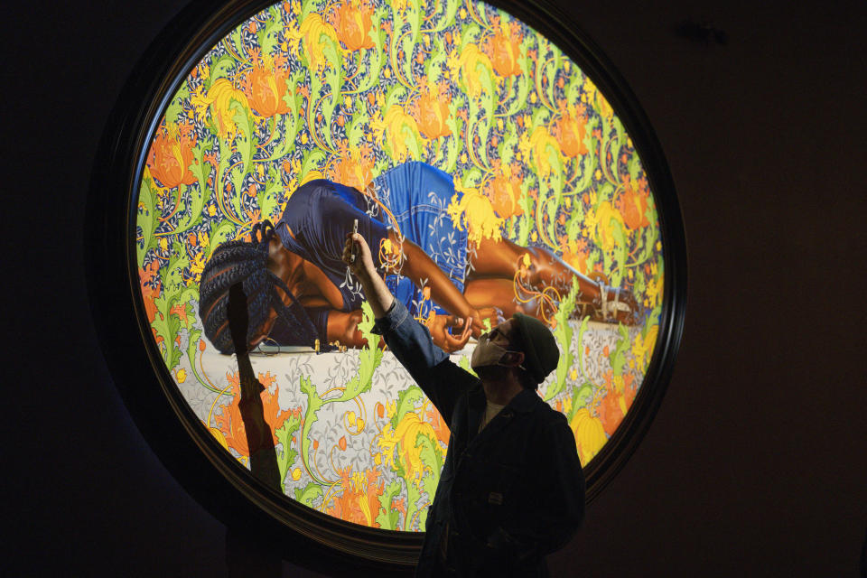 A man takes a picture of a painting by Kehinde Wiley titled "The Virgin Martyr St. Cecilia," at the de Young Museum in San Francisco, Friday, March 24, 2023. The painting is part of the "Kehinde Wiley: An Archaeology of Silence," exhibition. (AP Photo/Godofredo A. Vásquez)