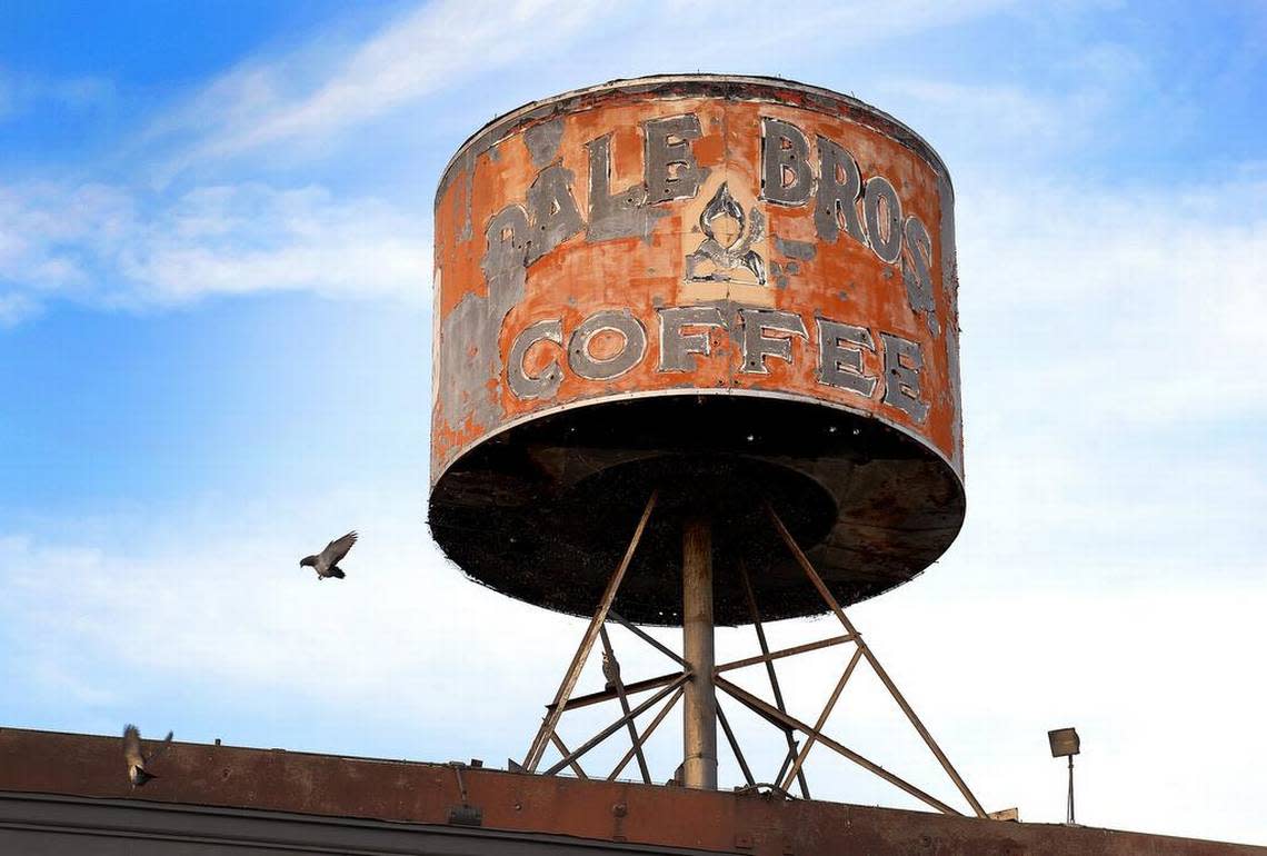 A bird flies from a rusted opening in the bottom of the Dale Bros. Coffee company coffee can sign atop a building on H Street in downtown Fresno on Wednesday, May 10, 2017.