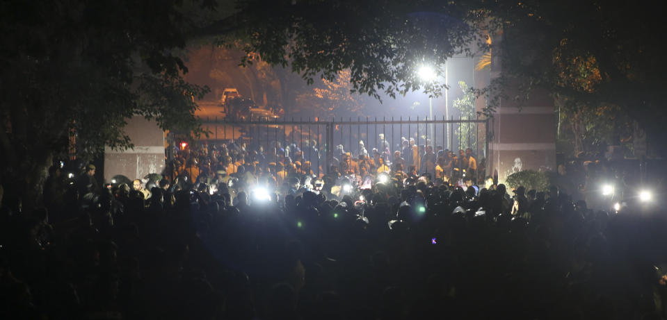 In this late Sunday, Jan.5, 2020 photo, police arrive outside the Jawaharlal Nehru University after masked assailants beat students and teachers with sticks in New Delhi, India. More than 20 people were injured in the attack opposition lawmakers are trying to link to the government. (AP Photo)