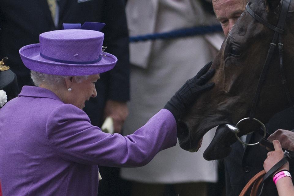 The Queen pats her horse, Estimate, in the winner’s enclosure after it won the Gold Cup on the third day of Royal Ascot in 2013. [Photo: Getty]