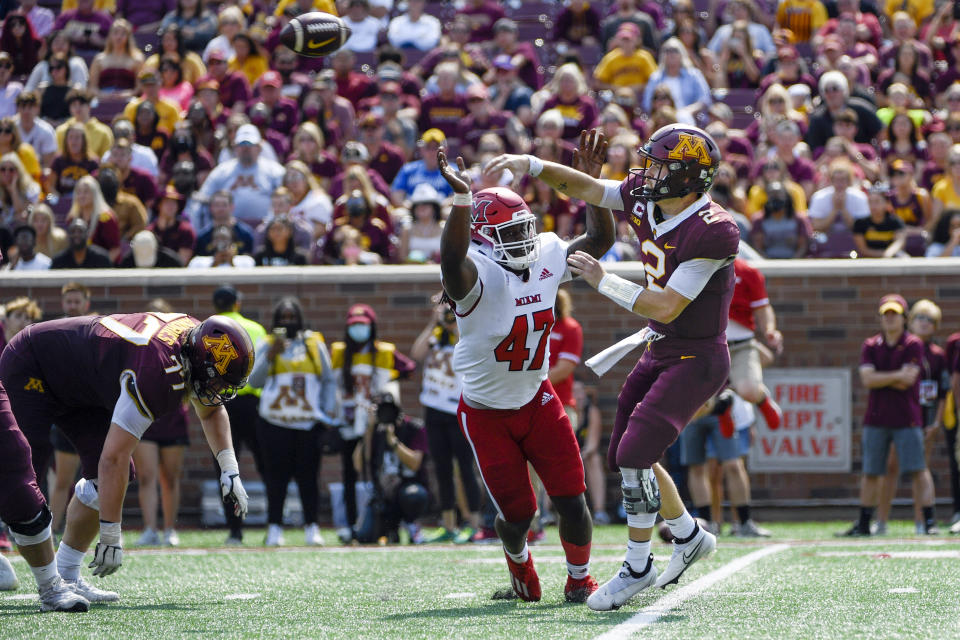 Minnesota quarterback Tanner Morgan, right, throws under pressure from Miami-Ohio defensive line Lonnie Phelps during the first half of an NCAA college football game on Saturday, Sept. 11, 2021, in Minneapolis. Minnesota won 31-26. (AP Photo/Craig Lassig)