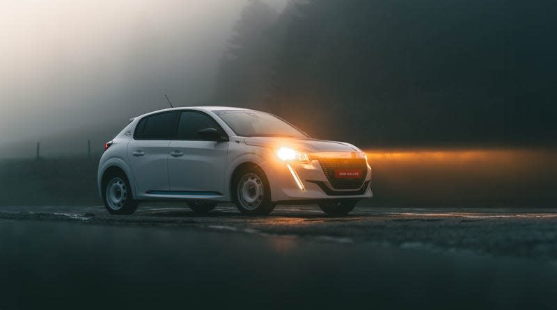 Front 3/4 view of a white Peugeot 208 Rallye in the fog
