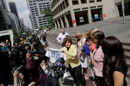 Attorney Gloria Allred holds a shirt with the minimum wages written on it as she speaks on behalf of several former Houston Texans cheerleaders while standing with fellow attorney Kimberley Spurlock outside of NFL headquarters in New York, U.S., June 4, 2018. REUTERS/Lucas Jackson