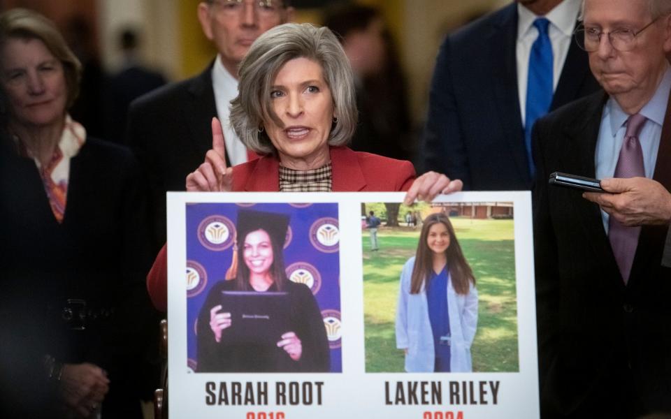 Senator Joni Ernst holds a poster with photos of Sarah Root, killed by an illegal immigrant who was drink-driving, and Laken Riley
