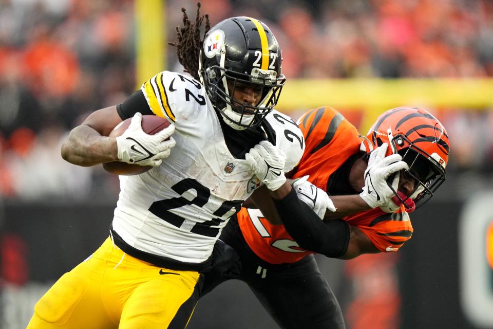 Pittsburgh Steelers running back Najee Harris (22) stiff arms Cincinnati Bengals cornerback Chidobe Awuzie (22) on a carry in the fourth quarter of a Week 12 NFL football game on Sunday, Nov. 26, 2023, at Paycor Stadium.