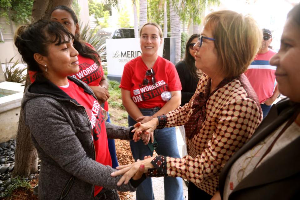State Sen. Maria Elena Durazo (right) after a news conference in October to address the allegation that hotels are using staffing agencies to hire homeless migrants as replacement workers for strikers. (Getty)