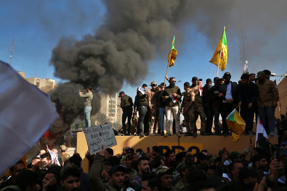 Protesters burn property in front of the U.S. embassy compound, in Baghdad, Iraq, Tuesday, Dec. 31, 2019. Dozens of angry Iraqi Shiite militia supporters broke into the U.S. Embassy compound in Baghdad on Tuesday after smashing a main door and setting fire to a reception area, prompting tear gas and sounds of gunfire. (AP Photo/Khalid Mohammed)