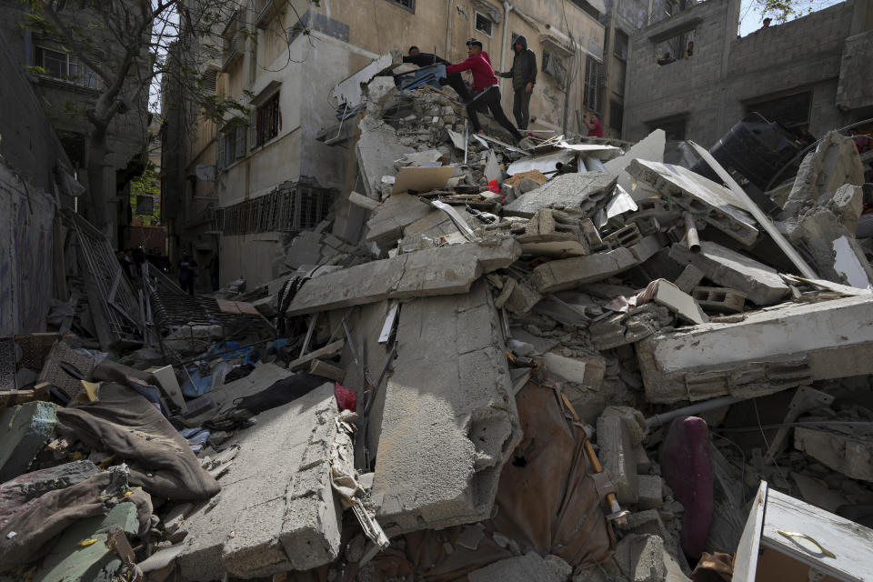 Palestinians inspect the rubble of destroyed building that the Israeli military said targeted the house of an Islamic Jihad member in Gaza City, Saturday, May 13, 2023. (AP Photo/Adel Hana)