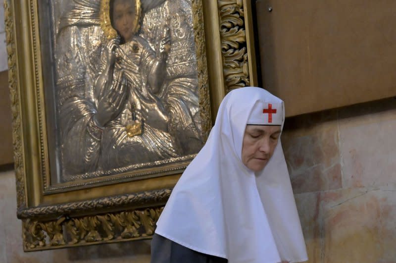 A nun joins the Greek Orthodox Patriarch of Jerusalem Theophilos III, not seen, in prayers during a memorial service for the souls of the Gaza war victims and the bombing in Gaza of the Church of Saint Porphyrios, in the Church of the Holy Sepulchre in the Old City of Jerusalem, on Sunday. Photo by Debbie Hill/UPI