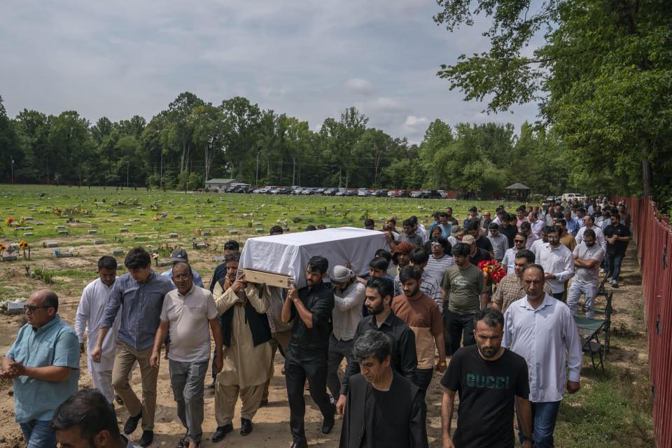 Friends and family carry the body of Nasrat Ahmad Yar, 31, to his grave during a funeral service at the All Muslim Association of America cemetery on Saturday, July 8, 2023 in Fredericksburg, Va. Ahmad Yar, an Afghan immigrant who worked as an interpreter for the U.S. military in Afghanistan, was shot and killed on Monday, July 3, while working as a ride-share driver in Washington. (AP Photo/Nathan Howard)