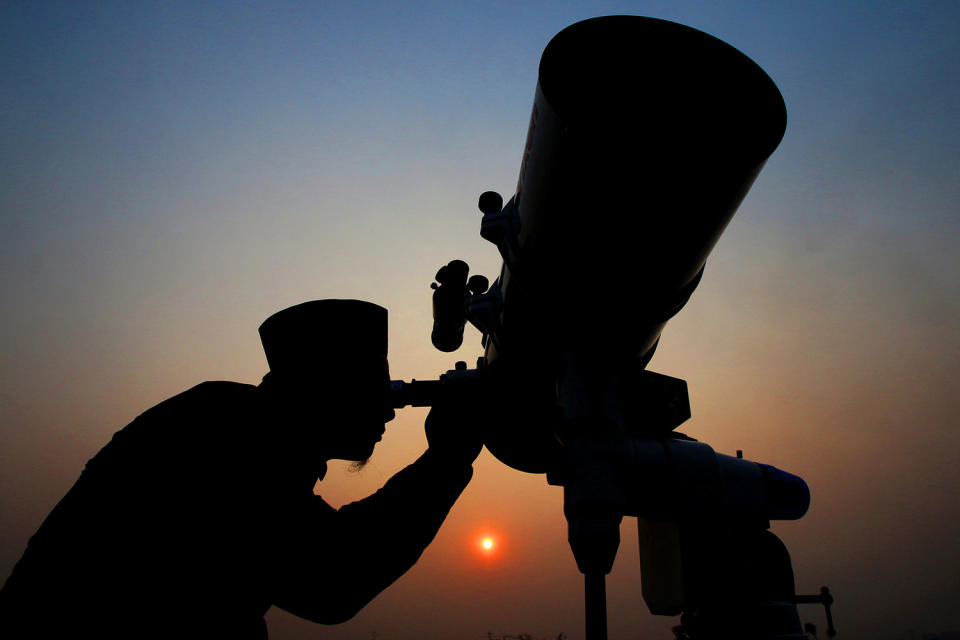 An official looks through a telescope for the sighting of the new moon in Jakarta