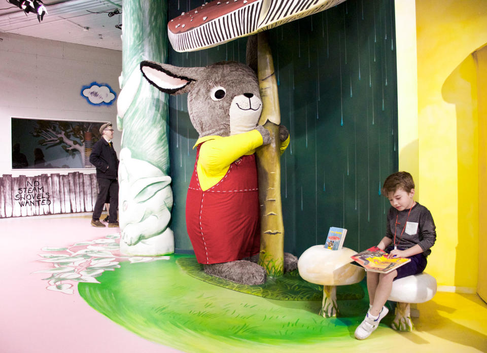 A child reads next to a large bunny sculpture that hugs a mushroom (Courtesy The Rabbit hOle)