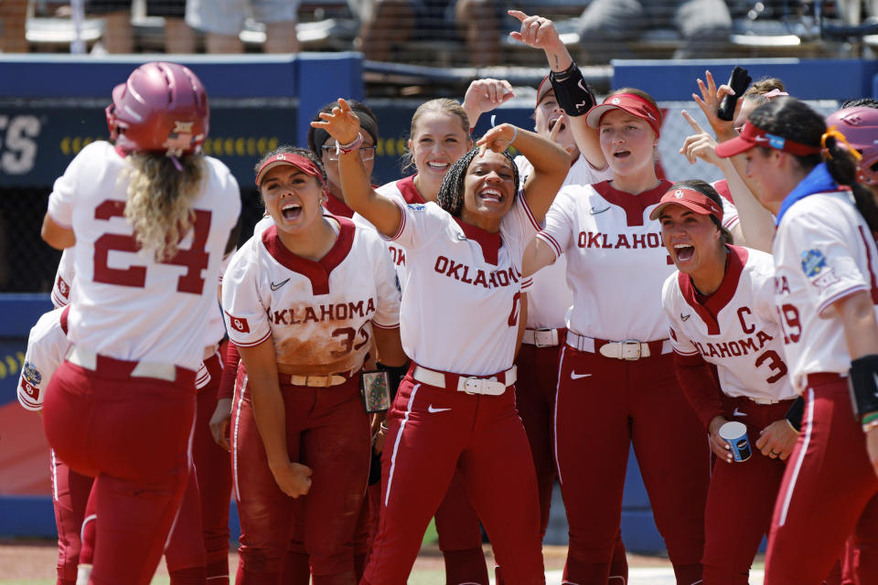 Oklahoma players celebrate as Jayda Coleman (24) runs to home plate after hitting a home run against Stanford during the third inning of an NCAA softball Women's College World Series game Monday, June 5, 2023, in Oklahoma City. (AP Photo/Nate Billings)