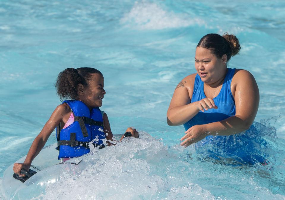 La’nya Brown, 8, splashes in the water with Chelsey Tibbs in the wave pool at Nashville Shores in Nashville, Tenn., Thursday, June 20, 2024.