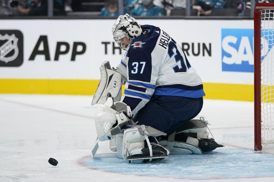 Winnipeg Jets goaltender Connor Hellebuyck defends against a shot by the San Jose Sharks during the first period of an NHL hockey game in San Jose, Calif., Saturday, Oct. 16, 2021. (AP Photo/Jeff Chiu)