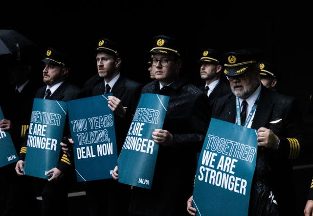 Aer Lingus pilots carry placards as they begin their strike