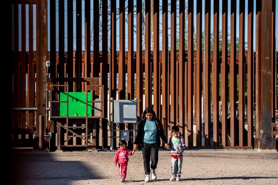 Migrants and asylum seekers from Peru wait for Border Patrol agents to pick them up after crossing the U.S.-Mexico border in San Luis, Ariz., on May 12, 2023.