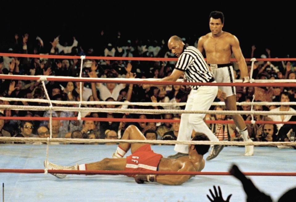 Muhammad Ali stands back as referee Zack Clayton calls the count over opponent George Foreman, red shorts, in Kinshasa, Zaire on Oct. 30, 1974.