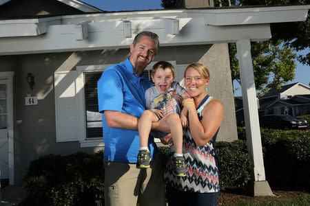 Danny and Bekah Bowman pose for a family picture with their 4-year old son Ely outside their home in Irvine, California, U.S. August 30, 2017. REUTERS/Mike Blake/Files
