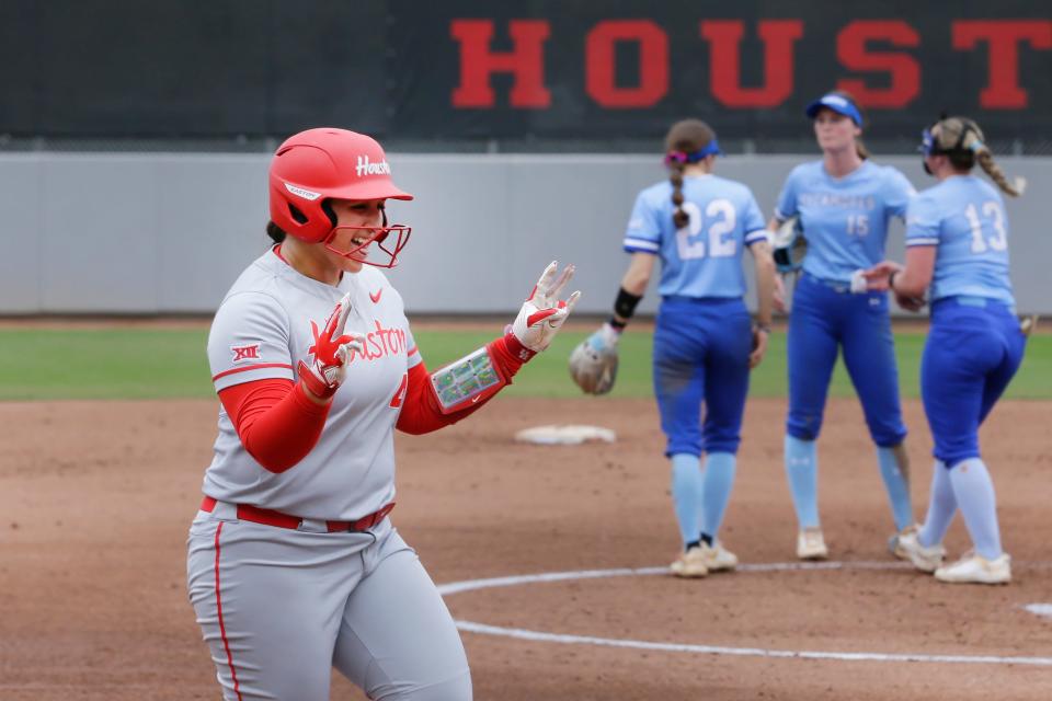 Houston's Bree Cantu, left, celebrates as she round the bases on her two run home run against Indiana State during the first inning of an NCAA softball game on Saturday, Feb.10, 2024, in Houston. (AP Photo/Michael Wyke).