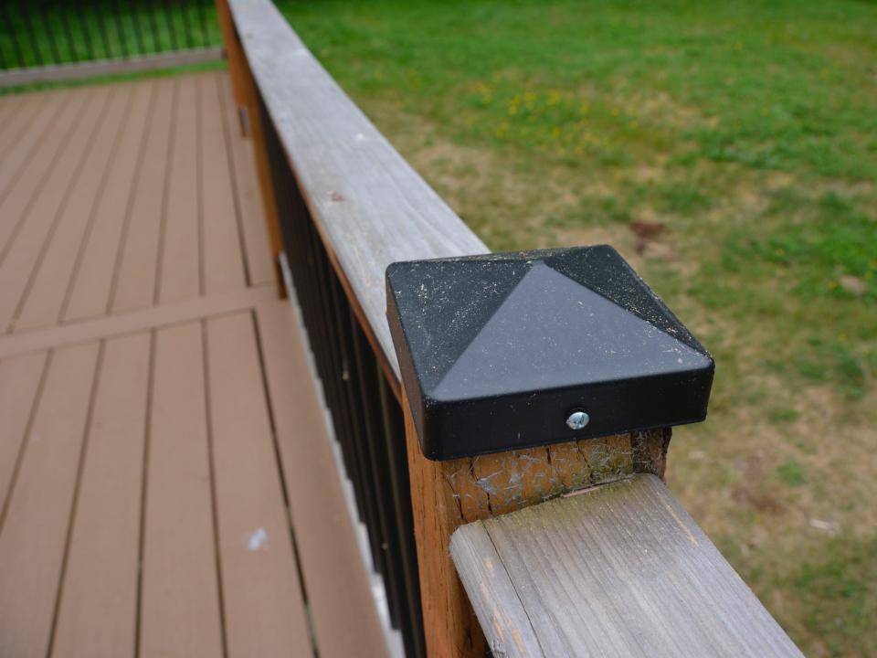 wood post with black topper on it along deck