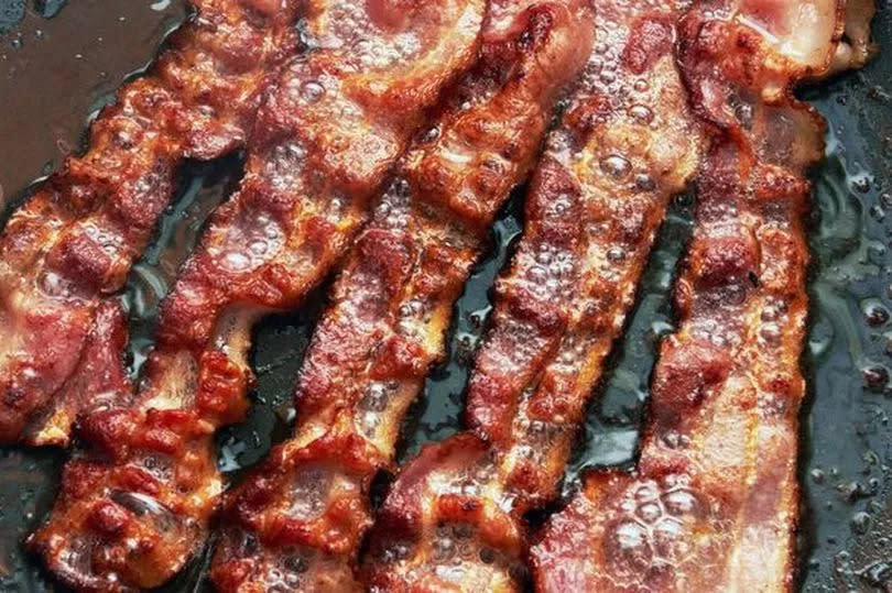 Bacon slice being cooked in frying pan