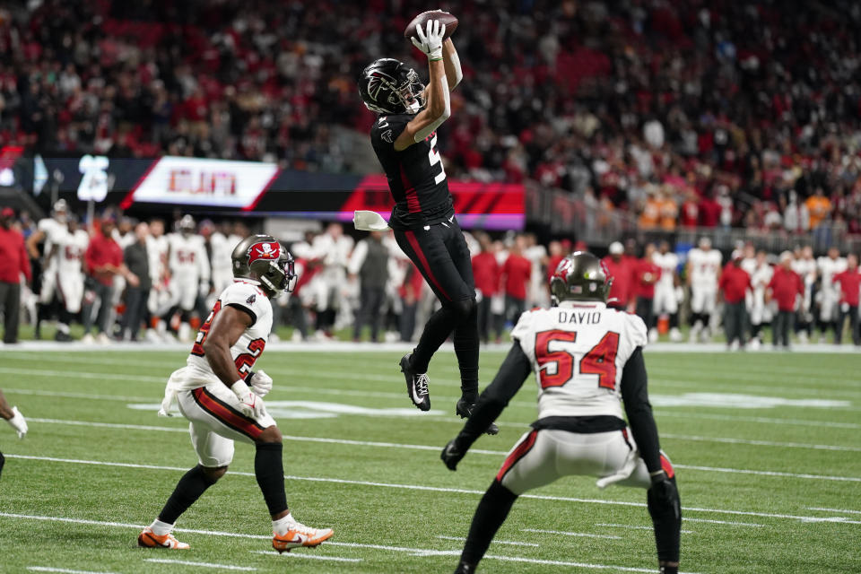 Atlanta Falcons wide receiver Drake London (5) makes a catch between Tampa Bay Buccaneers' Christian Izien (29) and Lavonte David (54) during the second half of an NFL football game, Sunday, Dec. 10, 2023, in Atlanta. (AP Photo/Mike Stewart)