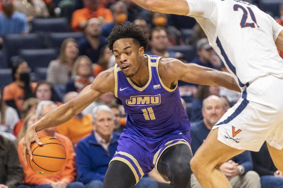 James Madison forward Justin Amadi (11) is defended by Virginia's Kadin Shedrick during the first half of an NCAA college basketball game in Charlottesville, Va., Tuesday, Dec. 6, 2022. (AP Photo/Erin Edgerton)