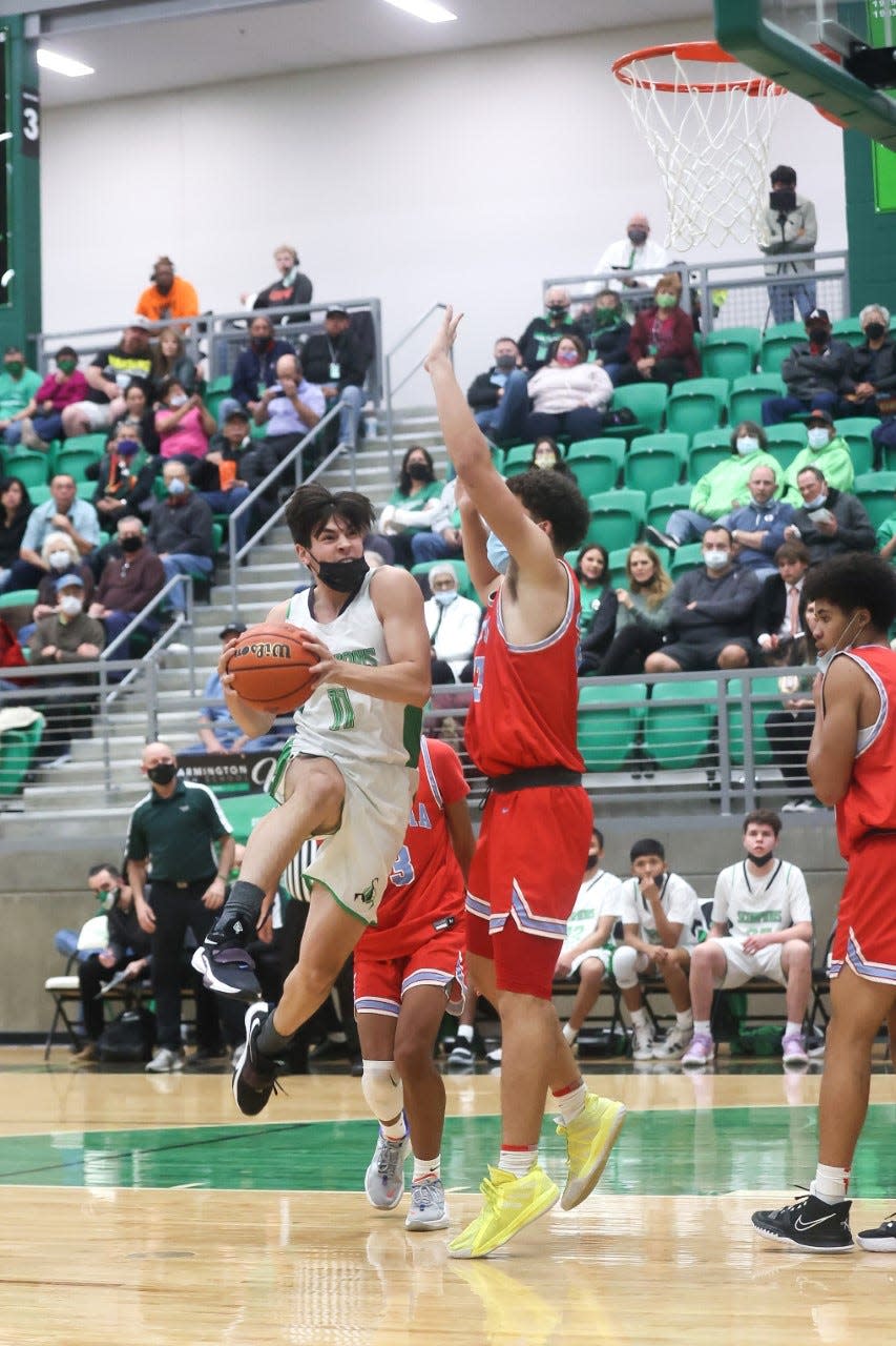 Farmington's Marcos Araiza goes up against Sandia's Sean Johnson in the paint during the third quarter of their game, Tuesday, Jan. 18, 2022 at Scorpion Arena.