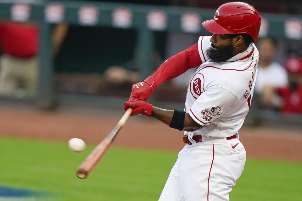 Cincinnati Reds' Brian Goodwin hits an RBI sacrifice fly during the first inning of the team's baseball game against the Pittsburgh Pirates in Cincinnati, Tuesday, Sept. 15, 2020. (AP Photo/Bryan Woolston)