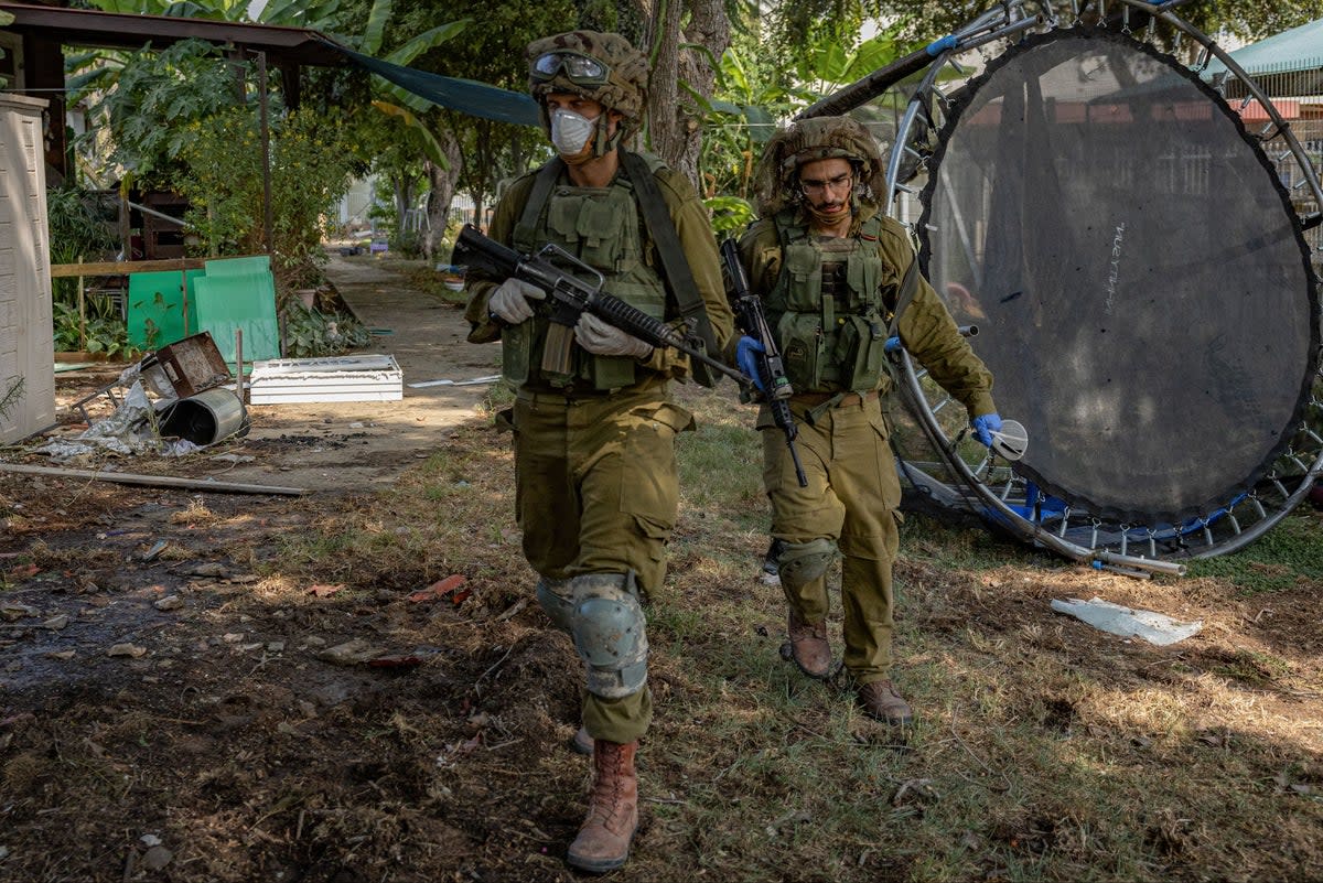 Israeli soldiers in the border village of Kfar Aza (Bel Trew/The Independent)