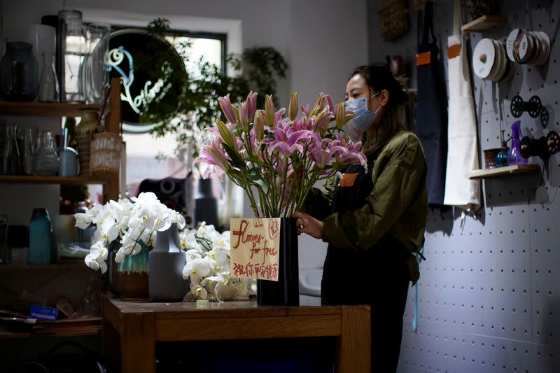 Florist Wang Haiyan, 41, works on flowers inside her shop as the country is hit by an outbreak of the new coronavirus, in Shanghai
