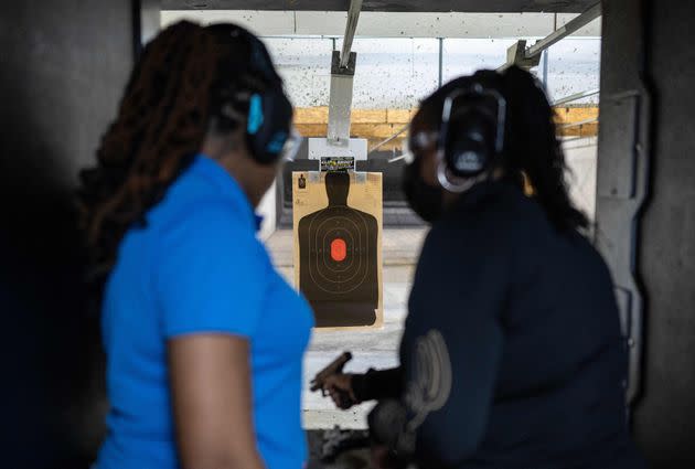 Vernice Howard (right) who started classes after a neighbor was assaulted at gunpoint, prepares to fire a Glock handgun as firearms instructor Taniece Reed, CEO and founder of Pretty Shooters Firearms Training, looks on at the Maryland Small Arms Range in Upper Marlboro, Maryland, on March 19, 2023.