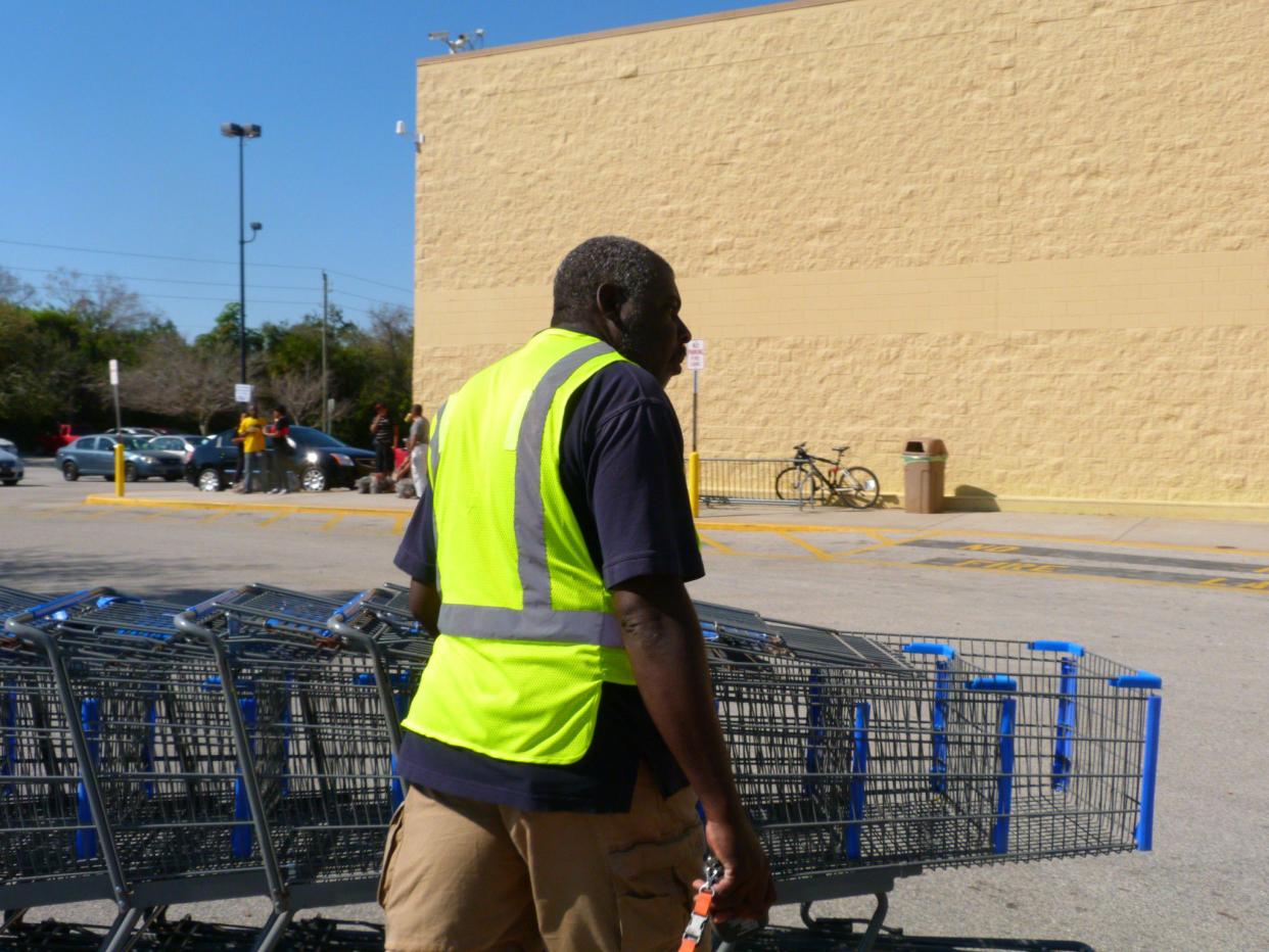 Walmart employee pushes shopping carts