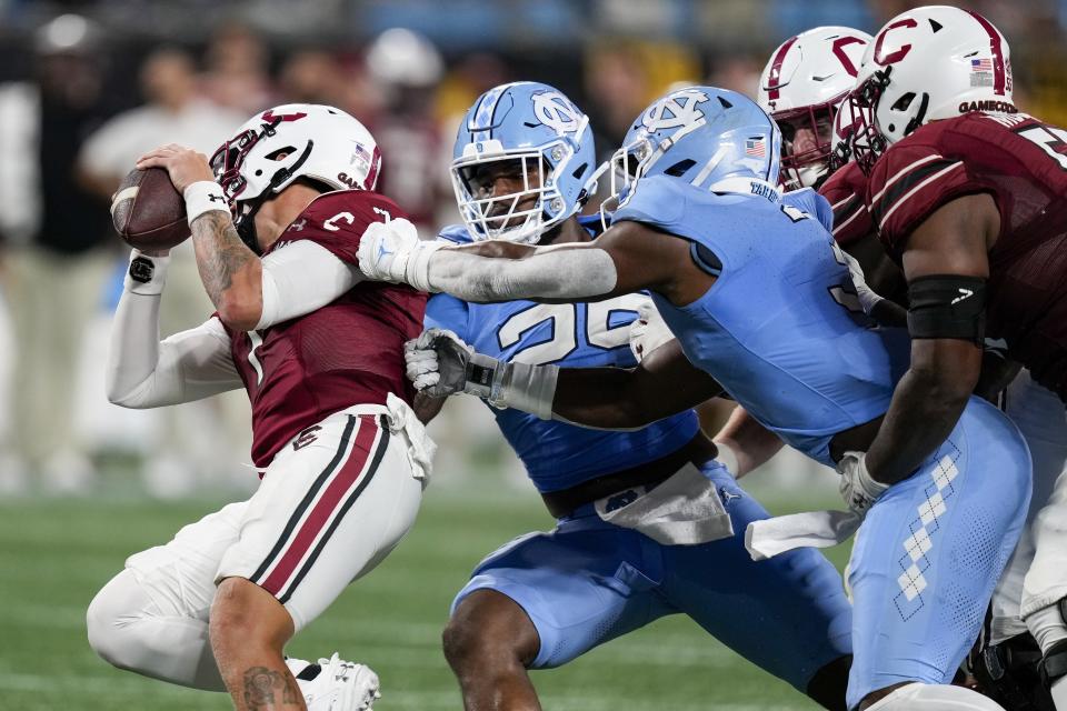 Sep 2, 2023; Charlotte, North Carolina, USA; North Carolina Tar Heels linebacker Kaimon Rucker (25) and linebacker Amari Gainer (3) tackle South Carolina Gamecocks quarterback Spencer Rattler (7) during the second half at Bank of America Stadium. Mandatory Credit: Jim Dedmon-USA TODAY Sports