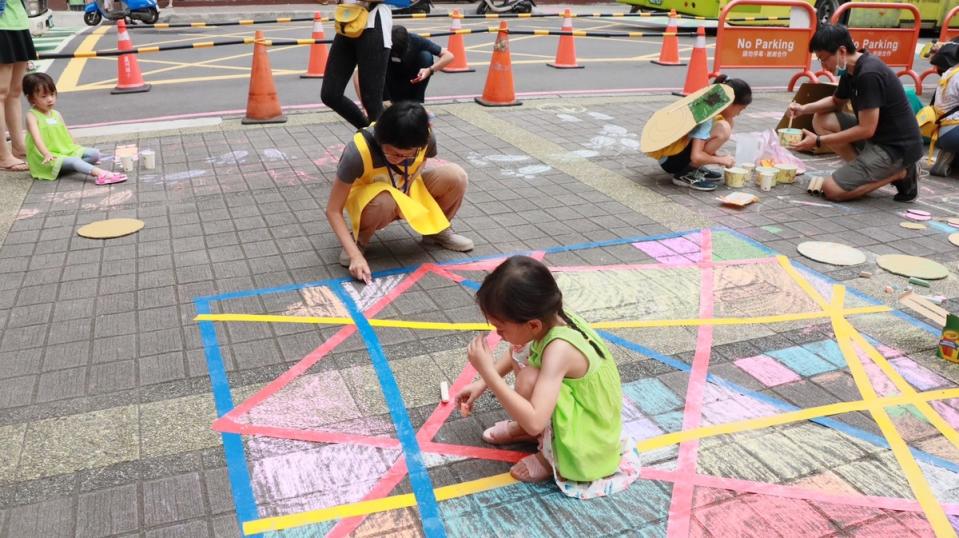 「街道遊戲實驗」是台灣還我特色公園行動聯盟帶領現場大小朋友，利用紙箱、線繩等素材在街道上佈置與遊戲，透過遊戲方式讓孩子們摸索街道空間，激發大小朋友對於人行環境的關心。   圖：新北市工務局提供