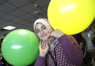 <p> Haya, a 13 year-old Syrian refugee from Homs, plays with balloons upon her arrival at Rome's Fiumicino international airport, Monday, Jan. 30, 2017. Italian government and church officials have welcomed 41 Syrian refugees at Rome's airport, saying they wanted to show solidarity at a time when the United States is sending refugees away and building walls to keep them out. (AP Photo/Alessandra Tarantino) </p>