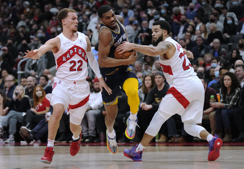 Memphis Grizzlies guard De'Anthony Melton (0) drives between Toronto Raptors guard Malachi Flynn (22) and guard Fred VanVleet (23) during the first half of an NBA basketball game Tuesday, Nov. 30, 2021, in Toronto. (Nathan Denette/The Canadian Press via AP)