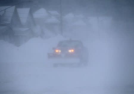 A snow plow works to clear Route 5 highway following an autumn snow storm in Lackawanna, near Buffalo, New York November 20, 2014. REUTERS/Aaron Lynett