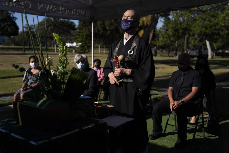 Shumyo Kojima, a head priest of Zenshuji Buddhist Temple, leads a memorial service for Giichi Matsumura at Woodlawn Cemetery in Santa Monica, Calif., Monday, Dec. 21, 2020. Giichi Matsumura, who died in the Sierra Nevada on a fishing trip while he was at the Japanese internment camp at Manzanar, was reburied in the same plot with his wife 75 years later after his remains were unearthed from a mountainside grave. (AP Photo/Jae C. Hong)