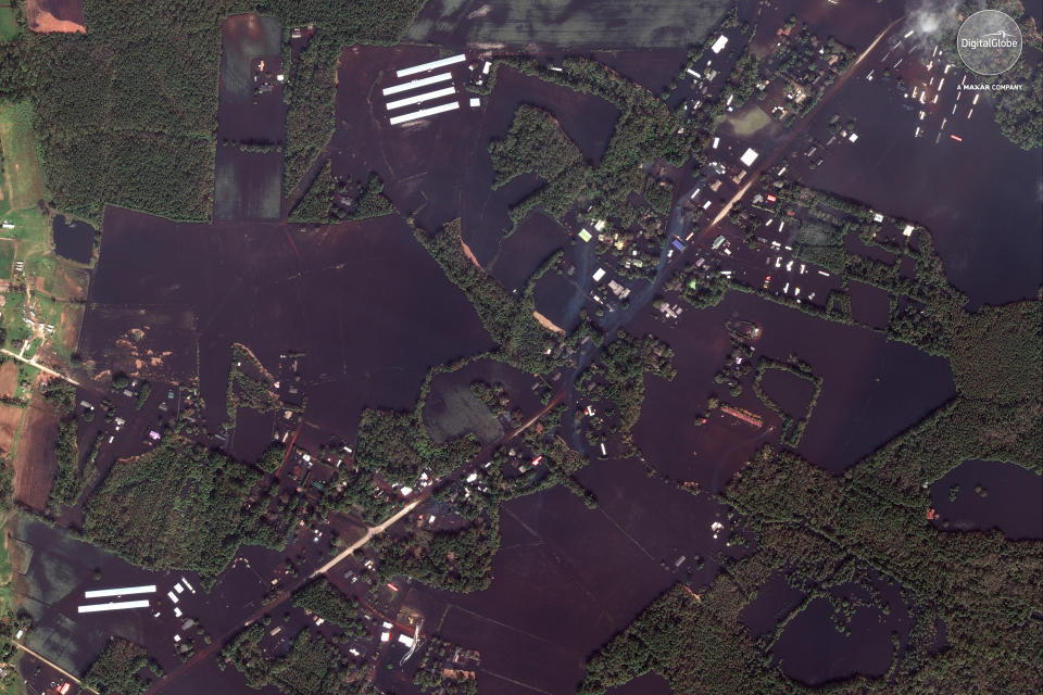 This Sept 20, 2018 satellite image provided by DigitalGlobe shows roads, farms and homes flooded from Hurricane Florence, northeast of Wallace, N.C. (DigitalGlobe, a Maxar company via AP)