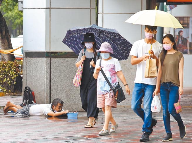 受疫情影響，六月份失業率創新高。圖為火因花颱風持續接近台灣，中央氣象局已發布海上颱風警報，22日一位殘疾者在風雨中的街頭乞討。（陳俊吉攝）
