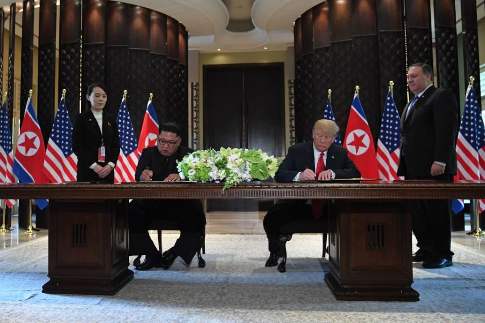 Trump and Kim Jong Un sign documents as US Secretary of State Mike Pompeo and the North Korean leader's sister Kim Yo Jong look on. Source: Getty