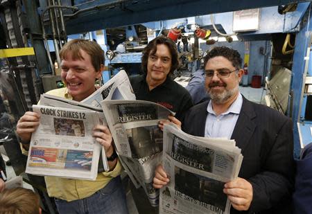 (R-L)Eric Spitz, president and co-owner of Freedom Communications, Los Angeles Register editor Ron Silvester and Orange County Register editor Rob Curley hold up some of the first copies of the inaugural Los Angeles Register newspaper as it runs off the presses in Santa Ana, California April 16, 2014. REUTERS/Lucy Nicholson